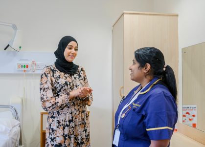 A consultant and a nurse convers in a patient's room