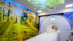 The MRI room with calming natural scenes on the walls and ceiling