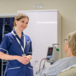 A nurse speaking with a patient in their room