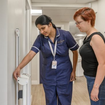 A nurse prepares scales to weigh a patient