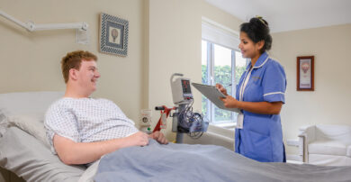 A nurse talks with a patient in their private room